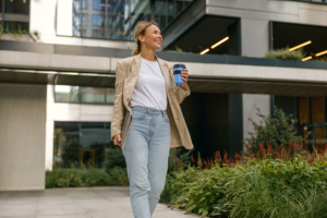 A woman walking confidently outdoors. Understanding breast implant illness rash symptoms is the first step toward recovery and systemic health.