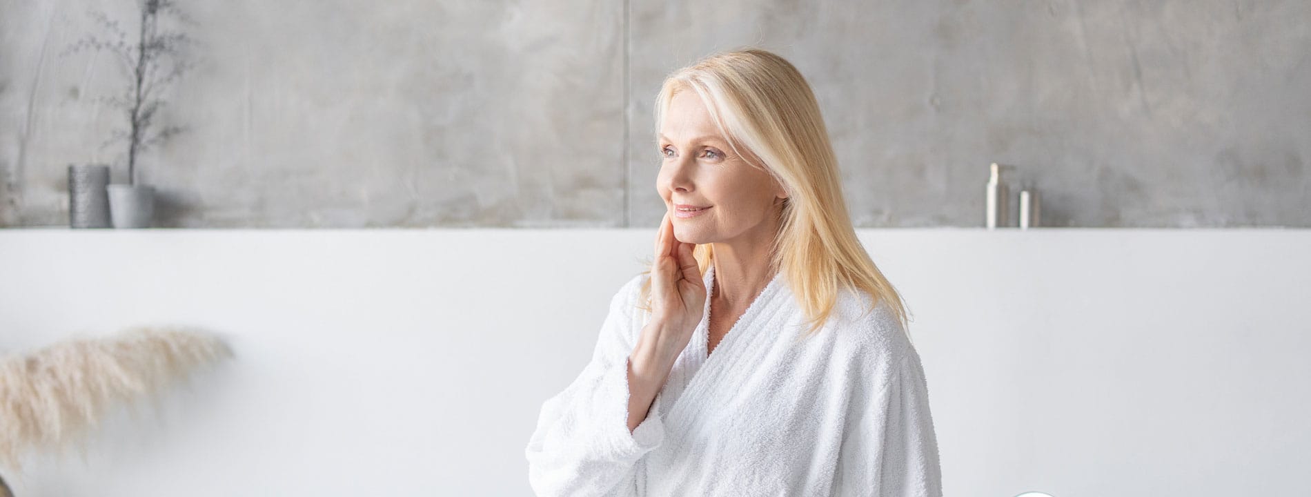 Woman with blonde hair smiling in modern bathroom setting