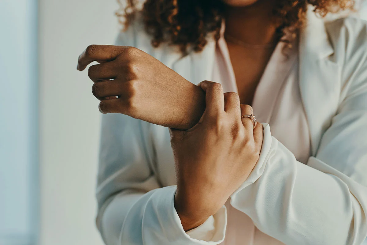 Woman examining her wrist with fingers, assessing hand pain