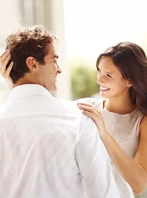 Smiling couple facing each other outdoors in natural daylight
