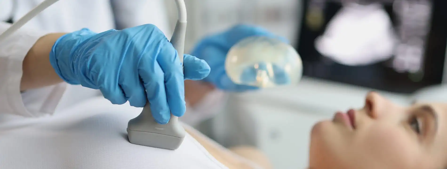 Cosmetic surgeon in blue gloves performing ultrasound treatment on patient's face