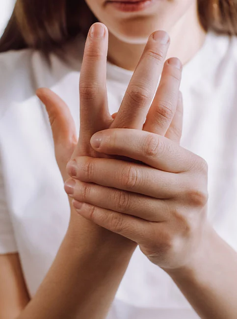Child's hand showing fingers held at bent angles, demonstrating trigger finger position