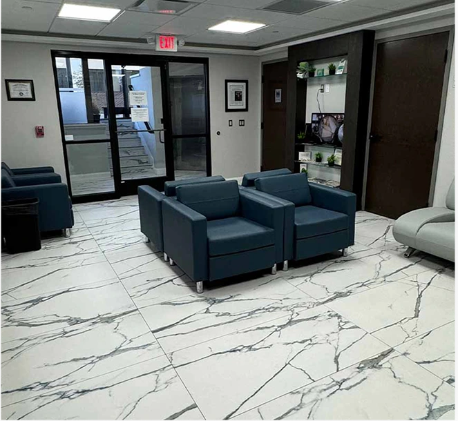 Modern plastic surgery practice waiting room with blue leather chairs and marble flooring