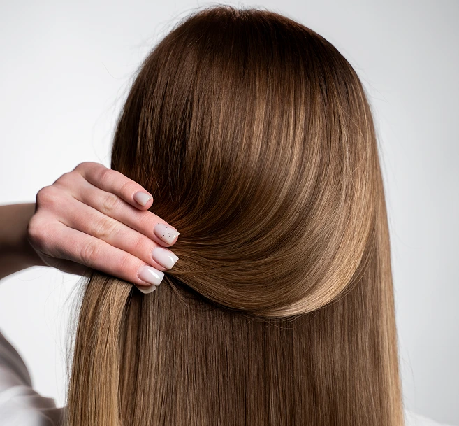 Woman running hand through long brown hair showing hair texture and shine