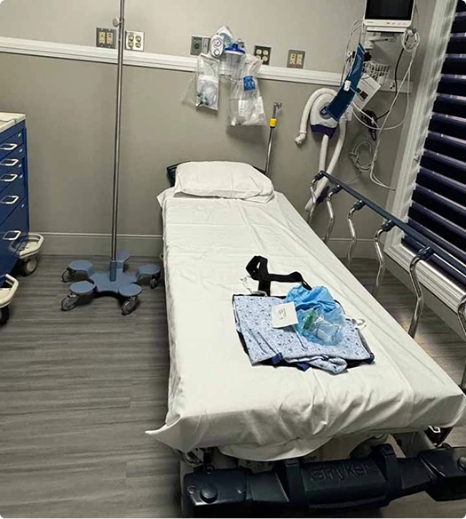 Surgical bed with sterile supplies and monitoring equipment mounted on wall