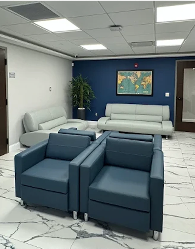 Modern surgical consultation waiting room with blue accent wall, gray seating, and world map artwork
